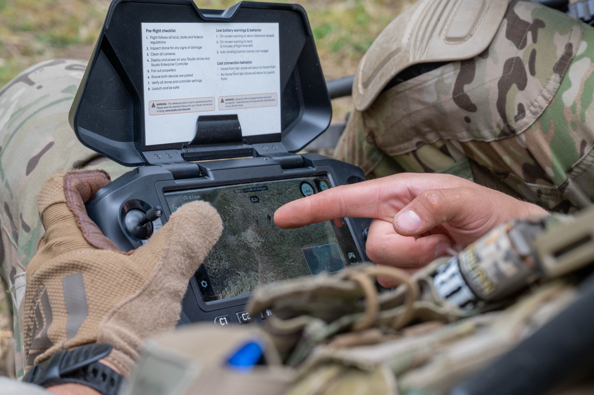 Soldier operating small UAS drone controller during tactical field training